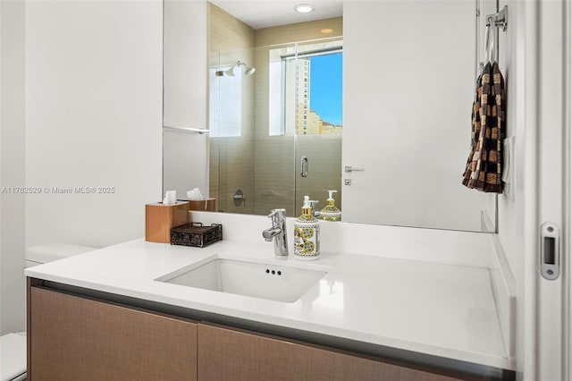 bathroom featuring vanity, toilet, and a tile shower