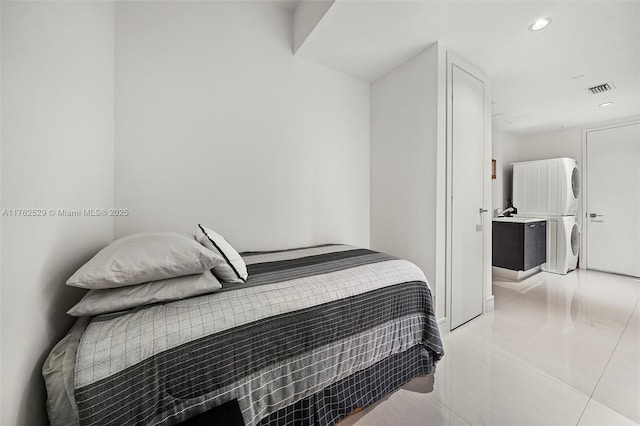 bedroom with stacked washer / dryer, light tile patterned flooring, recessed lighting, and visible vents