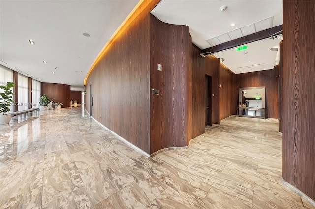 hall featuring marble finish floor and wood walls