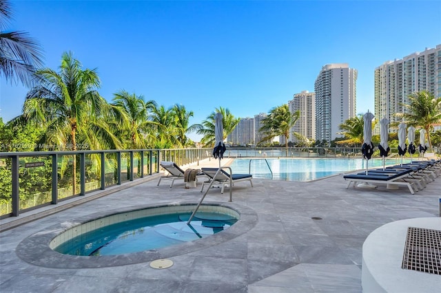 community pool with a patio, a city view, and a community hot tub