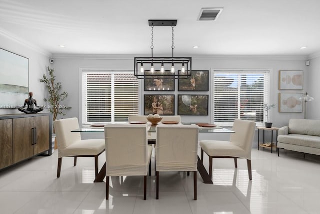 dining space with light tile patterned floors, visible vents, an inviting chandelier, and ornamental molding