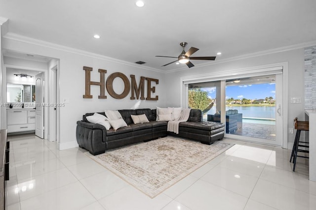 living area with a water view, a ceiling fan, crown molding, light tile patterned floors, and baseboards