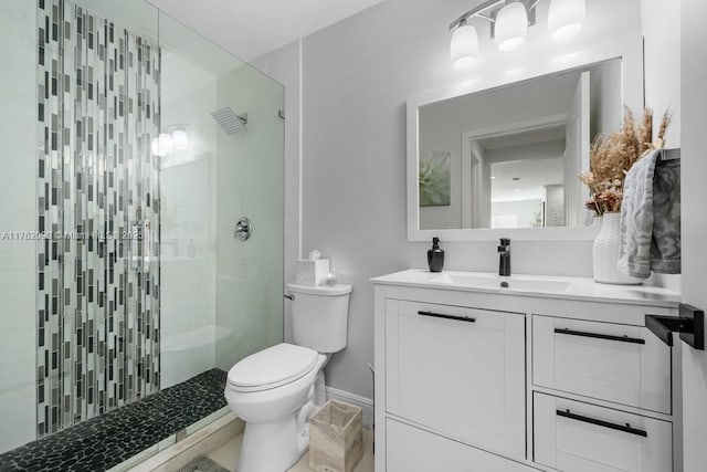 bathroom featuring baseboards, toilet, vanity, and walk in shower