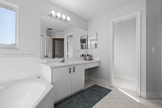 bathroom with vanity, baseboards, visible vents, tile patterned floors, and a bath