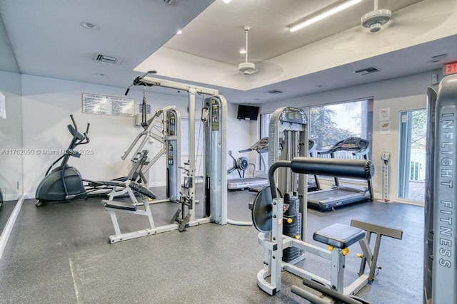 gym with baseboards, visible vents, and ceiling fan