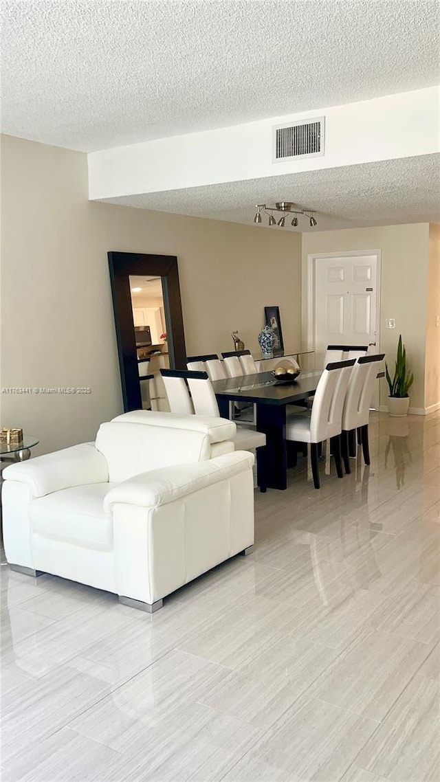 living area featuring visible vents and a textured ceiling