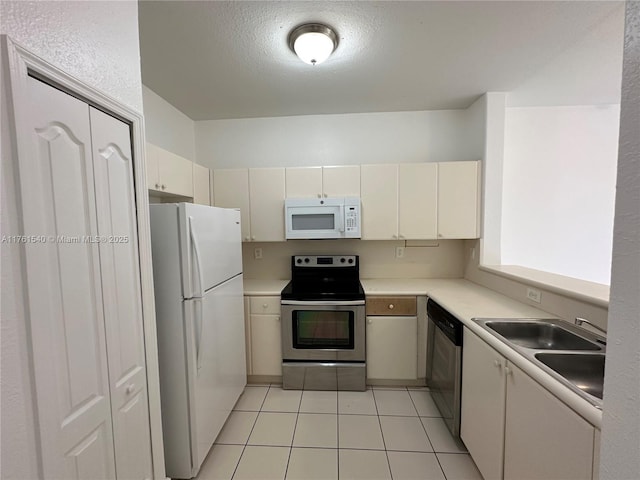 kitchen featuring light tile patterned flooring, a textured ceiling, stainless steel appliances, and light countertops