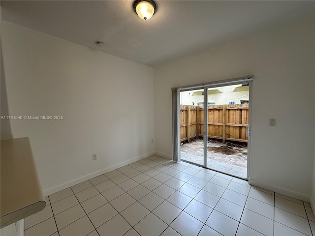 spare room with light tile patterned floors and baseboards