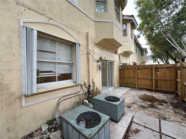 view of patio / terrace with central AC unit and fence