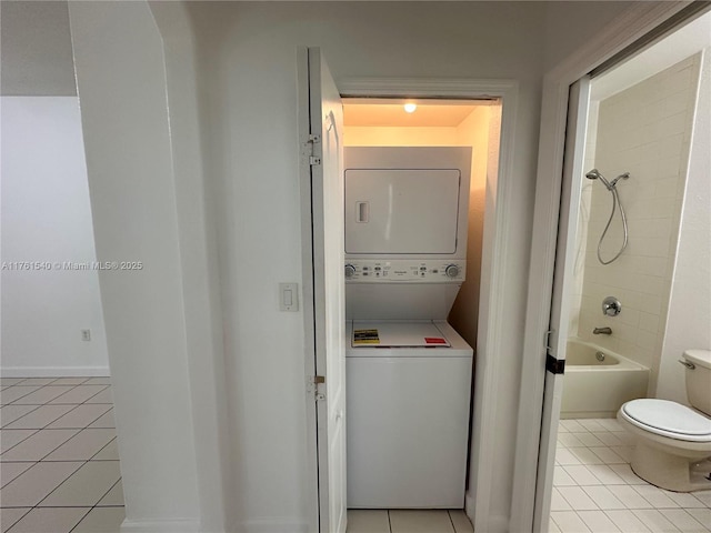 clothes washing area with light tile patterned floors, laundry area, and stacked washing maching and dryer