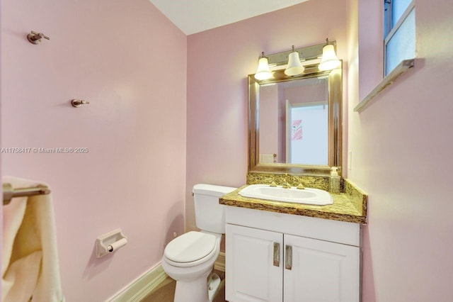 bathroom featuring baseboards, toilet, and vanity