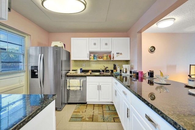 kitchen featuring decorative backsplash, appliances with stainless steel finishes, and white cabinetry