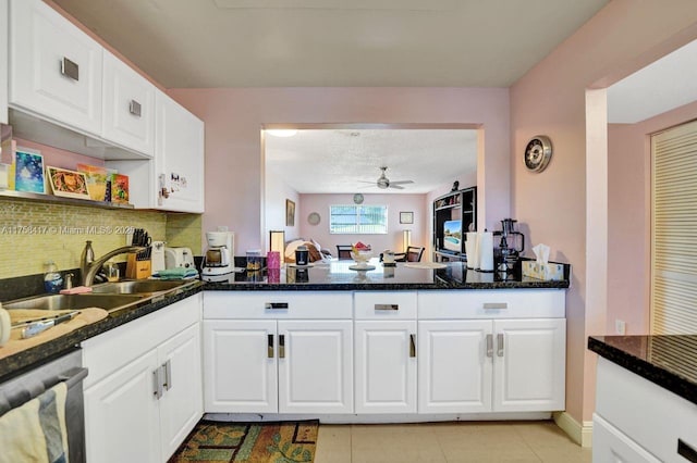 kitchen with decorative backsplash, a sink, white cabinetry, dishwashing machine, and ceiling fan