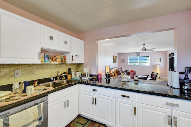 kitchen featuring backsplash, dishwasher, white cabinets, and a sink