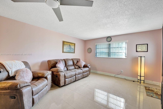 living area with light tile patterned flooring, a textured ceiling, baseboards, and ceiling fan