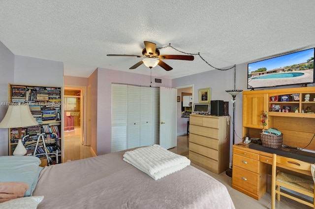 bedroom featuring a ceiling fan, visible vents, a closet, and a textured ceiling