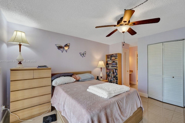 bedroom featuring light tile patterned floors, baseboards, a textured ceiling, and ceiling fan