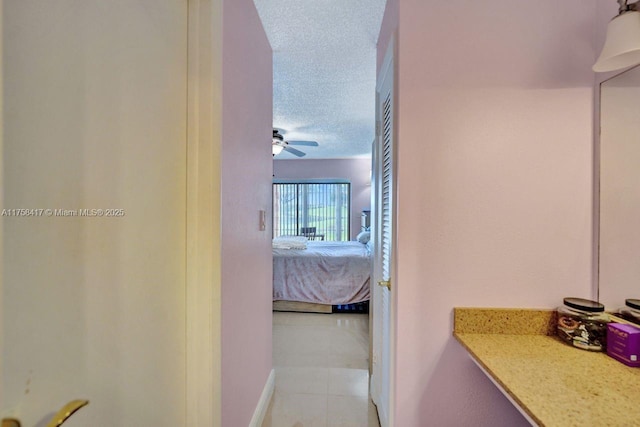 ensuite bathroom with tile patterned floors, a textured ceiling, ensuite bath, and a ceiling fan