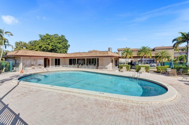 view of swimming pool with a patio and fence