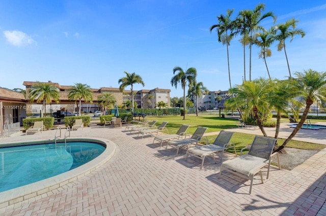 pool with a patio and a yard