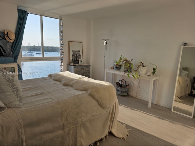 bedroom featuring expansive windows and wood finished floors