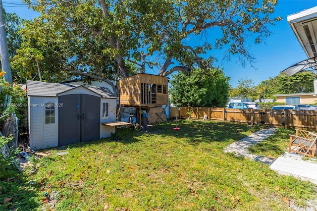 view of yard featuring a fenced backyard, a shed, and an outdoor structure