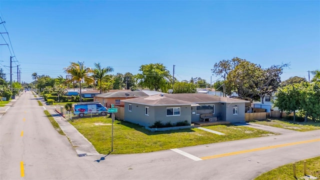 single story home featuring stucco siding, a front lawn, and fence