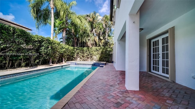 view of swimming pool with a patio area, french doors, and a pool with connected hot tub