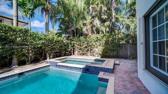 view of pool with a fenced in pool, an in ground hot tub, a fenced backyard, and a patio