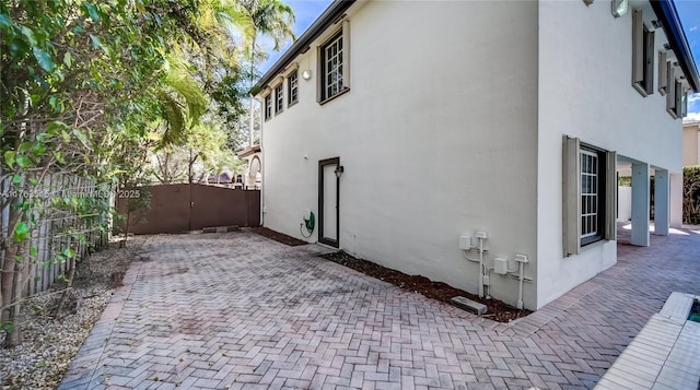 view of home's exterior featuring a gate, fence, and stucco siding