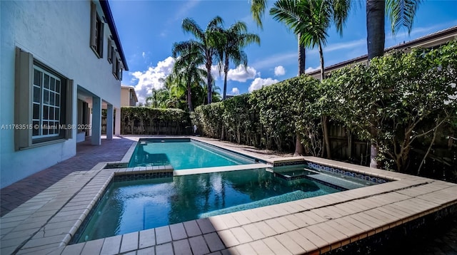 view of pool with a fenced backyard and a pool with connected hot tub