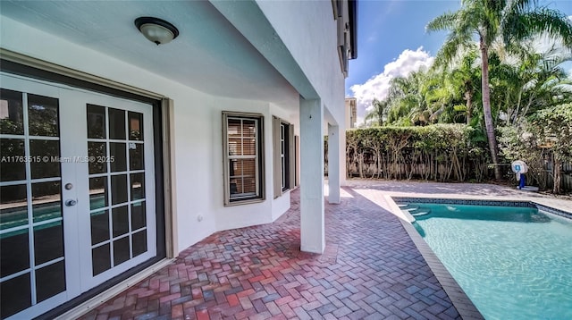 view of swimming pool featuring a patio area, a fenced in pool, french doors, and fence