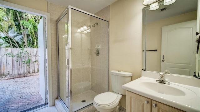 bathroom with visible vents, a shower stall, toilet, and vanity