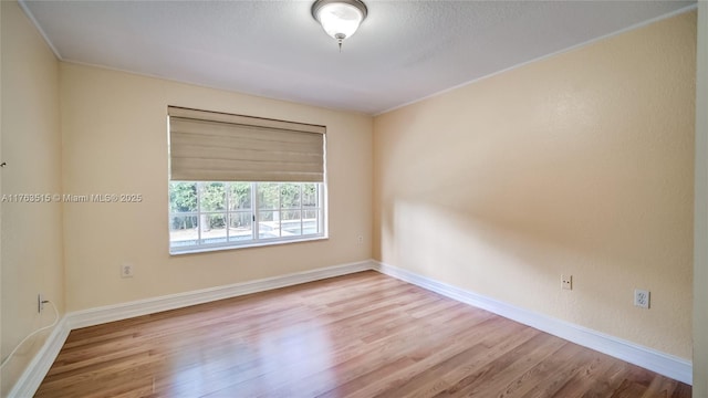 empty room featuring wood finished floors and baseboards