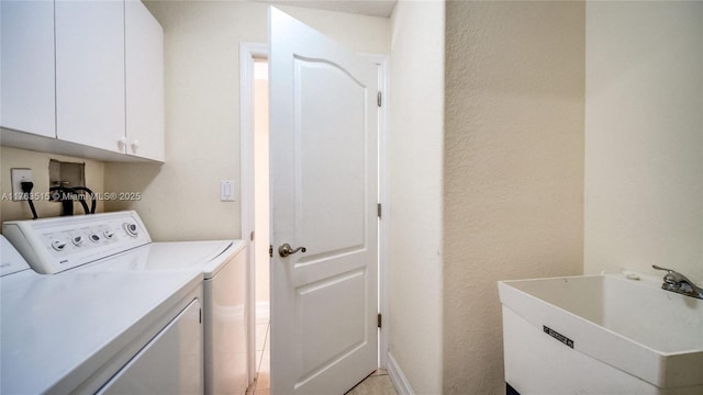 washroom featuring cabinet space, independent washer and dryer, baseboards, and a sink