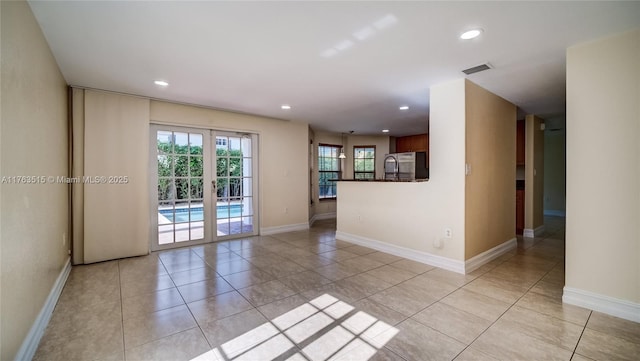 unfurnished room featuring light tile patterned floors, recessed lighting, visible vents, and baseboards