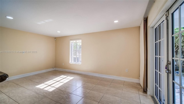 tiled empty room featuring recessed lighting and baseboards