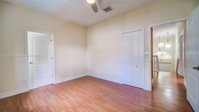 unfurnished bedroom with visible vents, baseboards, wood finished floors, a closet, and a ceiling fan