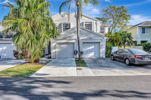 view of front of house featuring a garage, driveway, and stucco siding