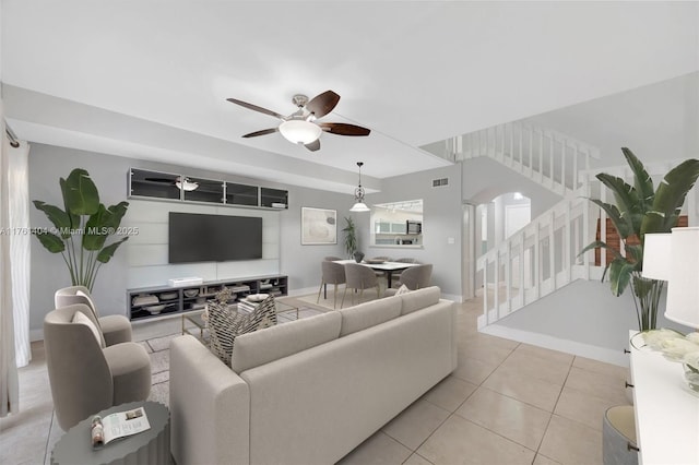 living room with visible vents, baseboards, stairs, light tile patterned floors, and a ceiling fan