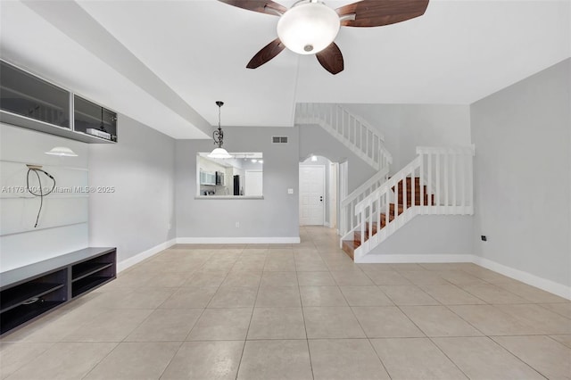 unfurnished living room with stairway, baseboards, visible vents, and ceiling fan