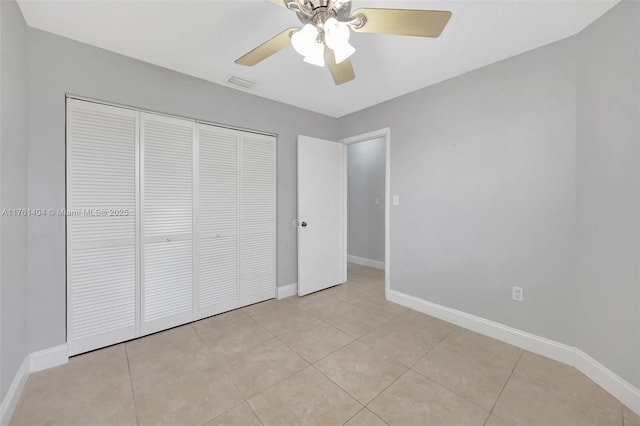 unfurnished bedroom featuring light tile patterned floors, baseboards, visible vents, and a closet