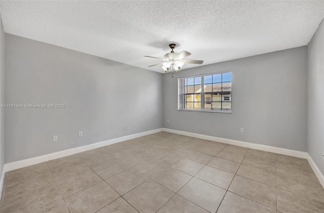 tiled spare room featuring a textured ceiling, baseboards, and ceiling fan