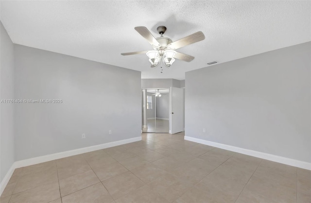 unfurnished room featuring baseboards, visible vents, a textured ceiling, and a ceiling fan