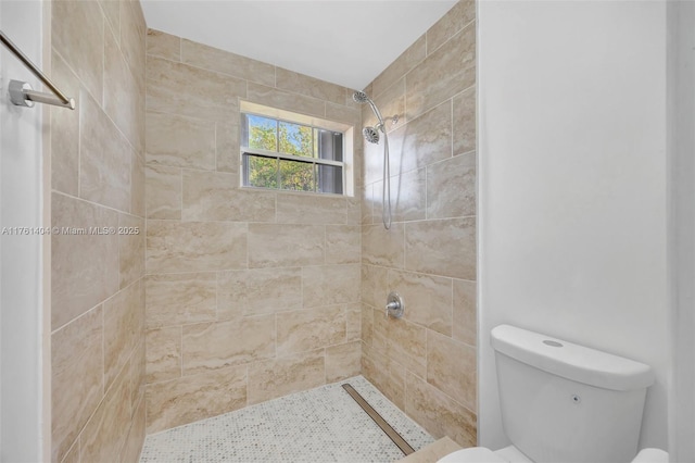 full bath featuring tiled shower and toilet