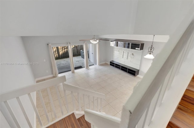 staircase with tile patterned flooring, vaulted ceiling, a ceiling fan, and baseboards