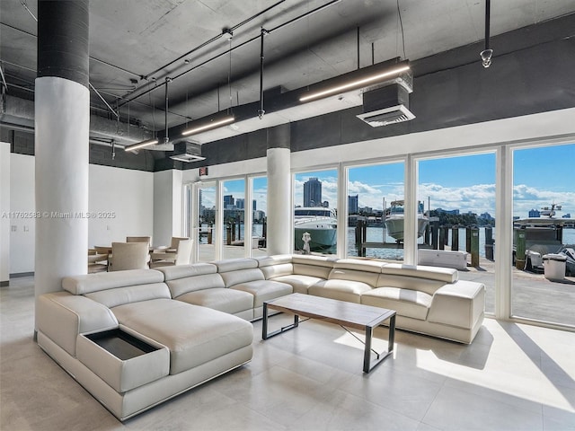 living room with a view of city, a healthy amount of sunlight, and a towering ceiling