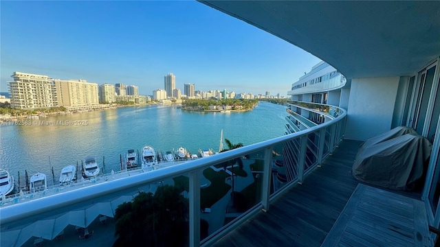 balcony with area for grilling, a view of city, and a water view