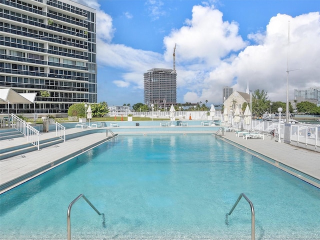 community pool with a city view and fence