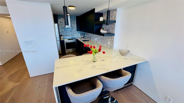 kitchen with open shelves, light stone counters, a sink, backsplash, and stainless steel electric range oven